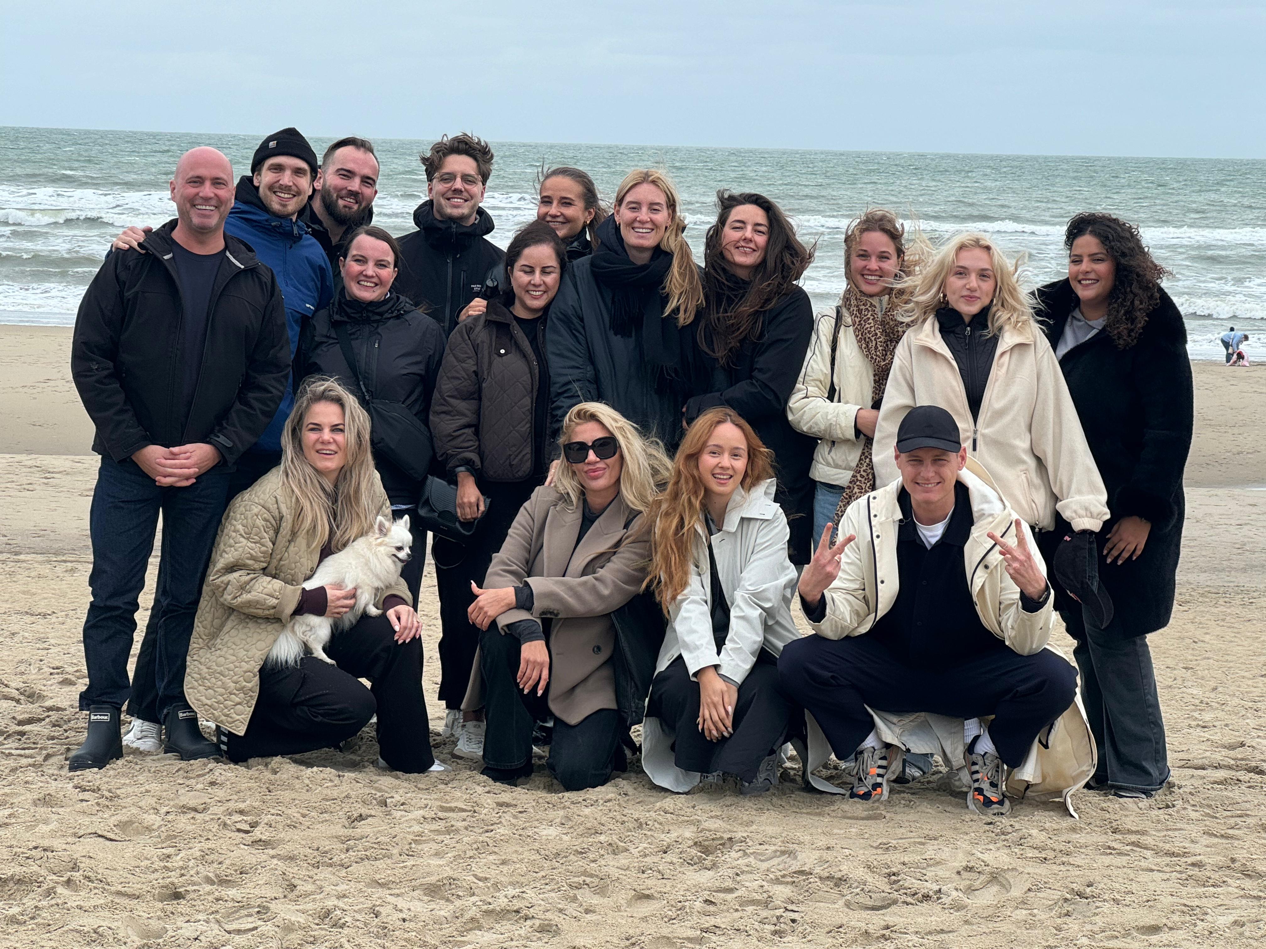 Group of people posing on a beach with ocean in the background