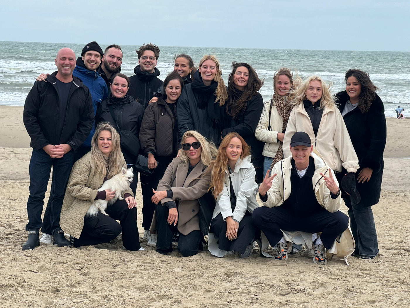 Group of people posing on a beach with ocean in the background